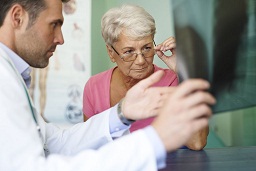 Adulto mayor siendo atendido por un profesional de la salud con una radiografía