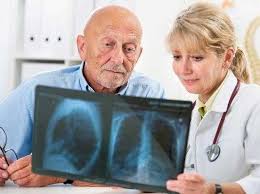 Profesional revisando una radiografía junto a un adulto mayor