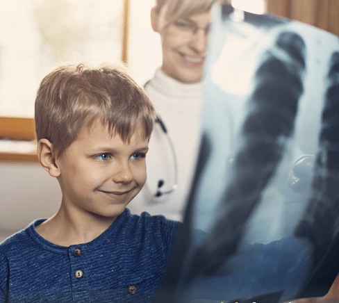 Niño observando una radiografía junto al profesional