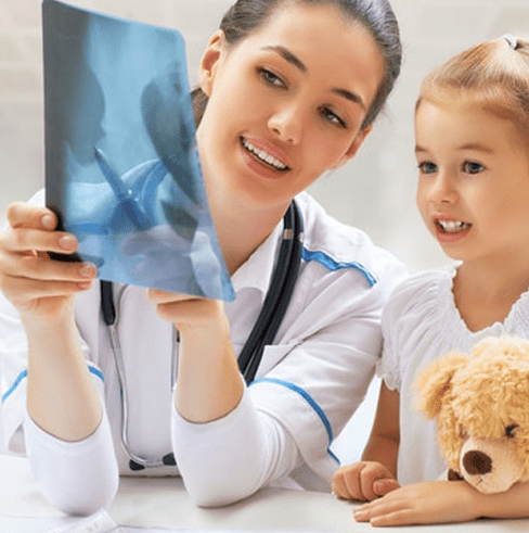 Técnica mostrando una radiografía a una niña
